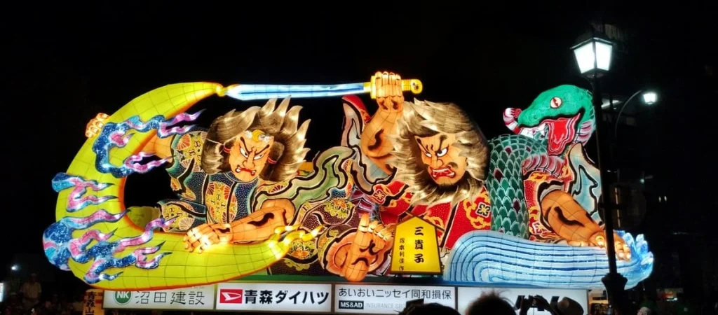 観客の前を光をまとって進む夜の大型ねぶた
